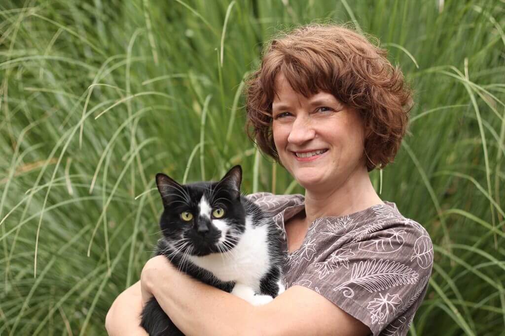 A Woman Holding a Black and White Cat
